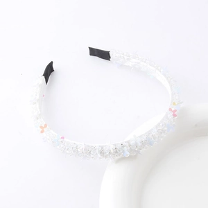 Detailed view of woven crystal flower headband with beads and pastel petals on white base