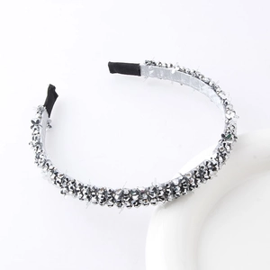 Detailed macro of silver rhinestone headband with black protective tips on white base