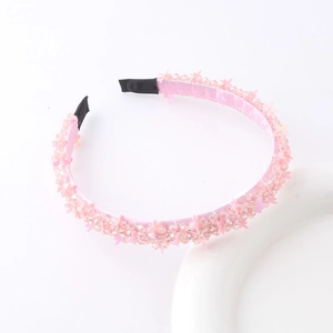 Detailed close-up of pink beaded floral headband with satin fabric and sparkling sequins