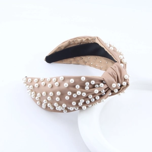 Detail showing faux leather wide knotted headband with white pearls and rhinestones decoration