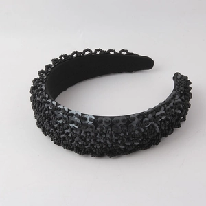 Detailed close-up of wide padded headband with intricate black bead and sequin embroidery