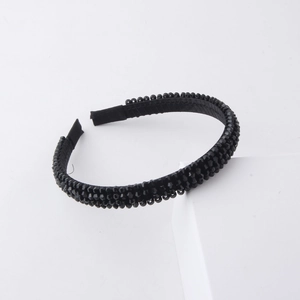 Detailed view of hand-woven black crystal beads on a minimalist fabric headband