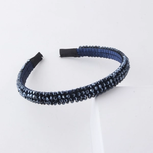Close-up of navy blue beaded headband with faceted crystal gems on a satin-wrapped frame