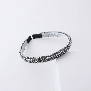 Detail of beaded headband featuring shiny silver-grey crystals and a soft satin lining