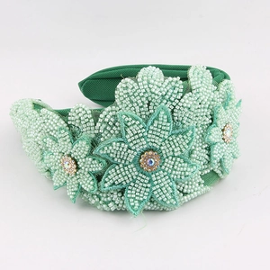 Detailed macro view of hand-sewn green beads and sparkling floral rhinestones on headband