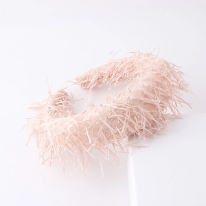 Detailed close-up of a light pink fringe headband featuring a soft and layered tassel texture