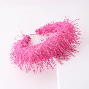 Detailed view of the rose pink headband featuring dense long tassels and feather texture