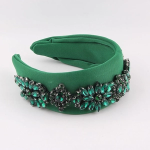 Green padded headband with wide fabric surface and sparkling rhinestone floral patterns