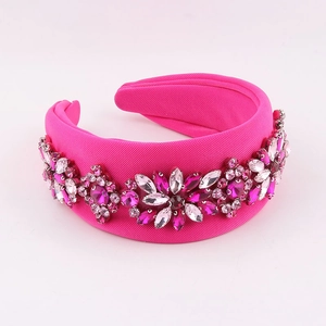 Detail of fuchsia padded headband with sparkling crystal floral clusters on textured fabric