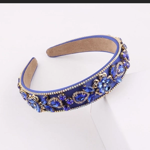Detail showing deep blue baroque headband with sparkling crystals and golden metal flowers