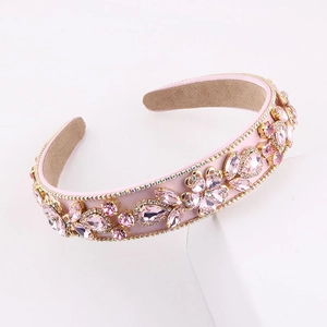 Close-up of pink Baroque rhinestone headband with gold bead trim on white platform