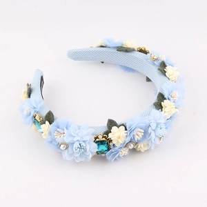 Detailed close-up of blue floral headband with baroque pearls and crystal gemstone