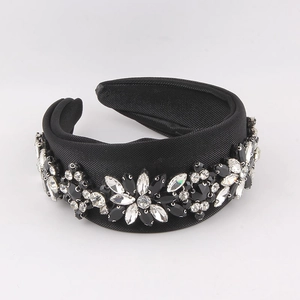 Detail of a padded wide black silk headband with sparkling rhinestone flower patterns