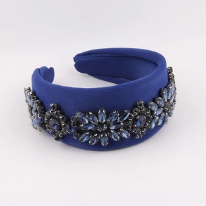 Detailed macro view of navy blue fabric headband with sparkling crystal floral patterns