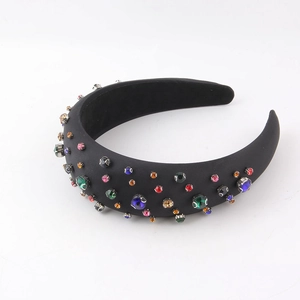 Detailed view of baroque sponge headband with colorful rhinestones on black fabric