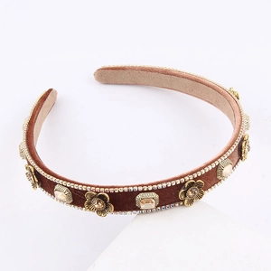 Close-up of brown velvet headband with golden metallic flowers and champagne rhinestones