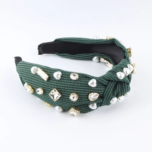 Fashionable dark green corduroy headband with heart pearls and crystals on white background