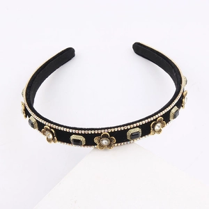 Detailed view of vintage velvet headband with golden metal flowers and rhinestone edges