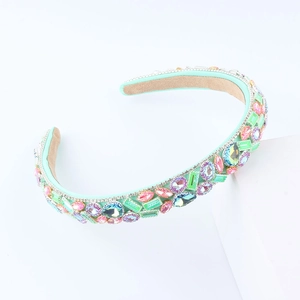Luxe wide sponge headband with vibrant colorful crystals on a mint green fabric base