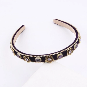 Detail of purple velvet headband with golden floral metal pieces and square rhinestones