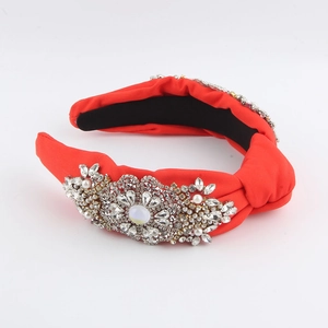 Detail of red fabric knotted headband featuring vintage rhinestone and pearl embellishments