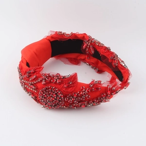 Vue détaillée du serre-tête baroque rouge avec strass luxueux et motifs de fleurs en dentelle