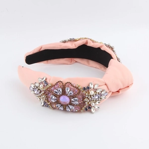 Pink fabric knotted headband with handcrafted crystals and pearls on white backdrop
