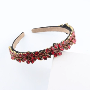 Detailed view of red rhinestone flower headband with gold metal and non-slip lining