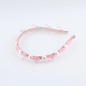 Dettaglio di cerchietto rosa con petali trasparenti, perle bianche e piccoli strass