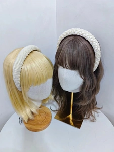 Detail showing two braided white pearl headbands with glossy faux pearl embellishments