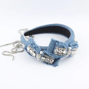 Detail of blue denim headband featuring layered bow with rhinestones and pearls