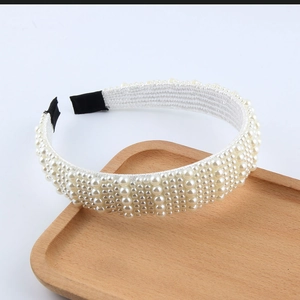Détail du serre-tête tressé de perles blanches de tailles mixtes sur base en tissu
