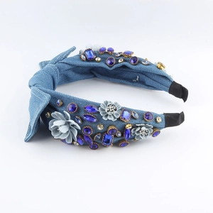 Detail of blue denim headband featuring navy rhinestones and grey fabric 3D flowers