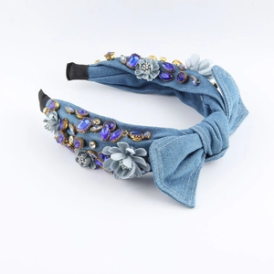 Detail of denim headband featuring blue fabric flowers and sparkling rhinestones