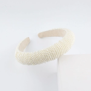 Detail of hand-woven cream sponge headband with densely set faux pearls and velvet lining