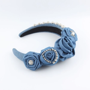 Detailed macro view of denim blue fabric floral headband with rhinestones and pearl centers