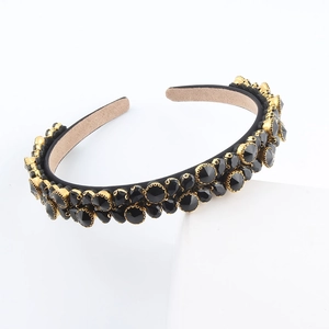 Close-up of vintage wide headband with black multifaceted crystals and gold claw settings