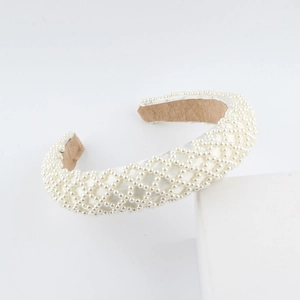 Detailed macro view of the white woven sponge headband with luxury pearl embellishments