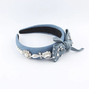 Detail showing blue denim headband with rhinestone flowers and faux pearl bow accents