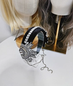Detailed macro of black velvet padded headband with crystal flower and fringe tassels