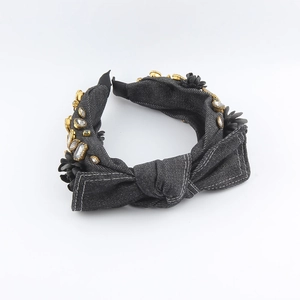 Detail of denim knotted headband with sparkling rhinestones and black floral charms