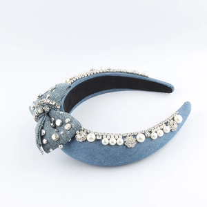 Close-up of blue denim headband featuring white pearls, rhinestones and a side bow