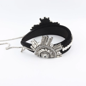 Close-up of black velvet headband with sparkling rhinestone tassel and vintage starburst detail