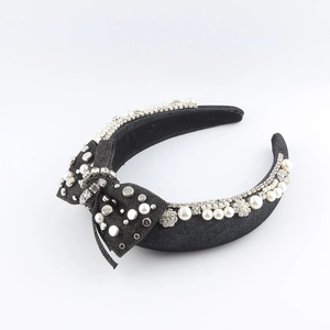Detail of denim sponge headband with white pearls, rhinestones and a side bow decoration