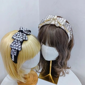 Détail de serre-têtes à nœud en strass de luxe en noir et crème avec cristaux brillants