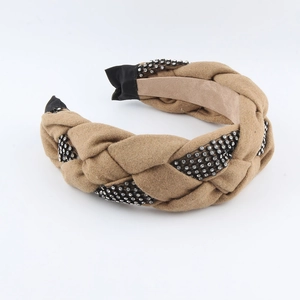 Detail of woven khaki fabric headband with sparkling rhinestones and black mesh design