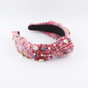 Detail eines rosa Tweed-Haarreifens mit weißen Perlen und funkelndem Kristallbesatz