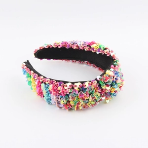 Macro detail of vibrant colorful sequins on a wide black fabric fashion headband