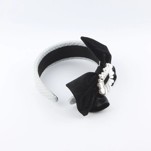 Detailed view of velvet bow headband with a heart-shaped pearl buckle and quilted fabric
