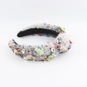Détail de serre-tête en tweed gris avec strass brillants et breloques de bonbons